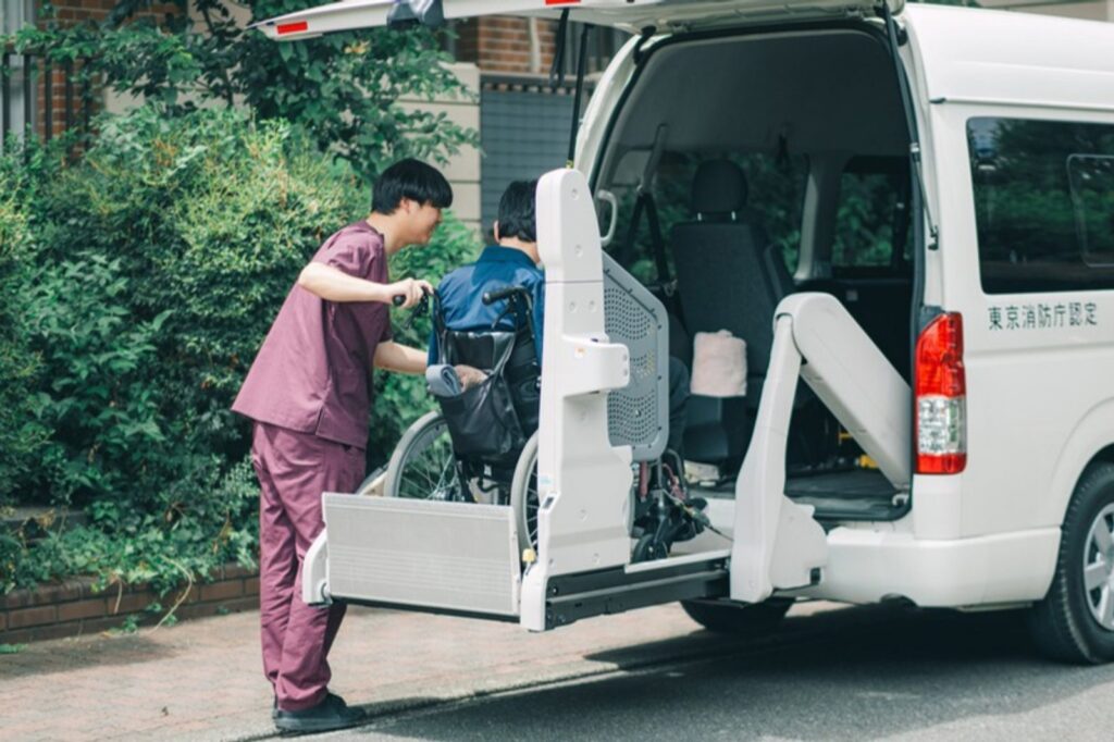 車いすの方の乗車をお手伝いするリーベルのスタッフと介護タクシー