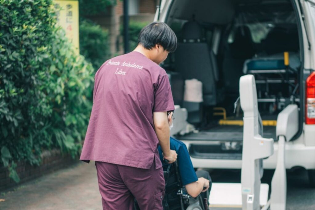 ご自宅の前で、車いすのまま車両へお連れするスタッフ