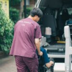 ご自宅の前で、車いすのまま車両へお連れするスタッフ